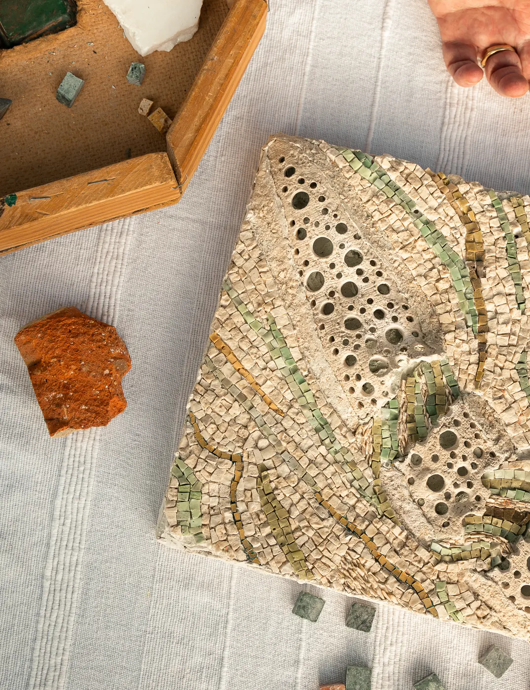 Mosaïques posées à plat près d'un cadre doré et de tesselles éparses