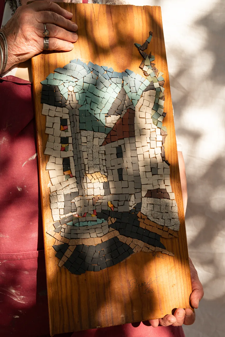 Une mosaïque de village aux toits bleus, montée sur bois